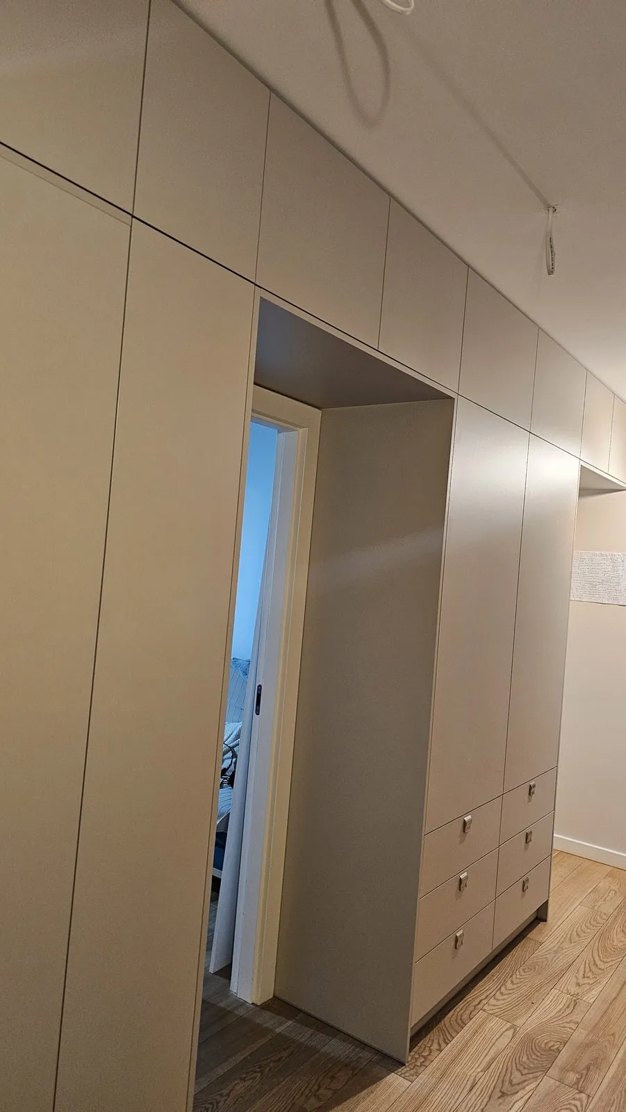 Beżowa zabudowa ścienna z ukrytymi drzwiami